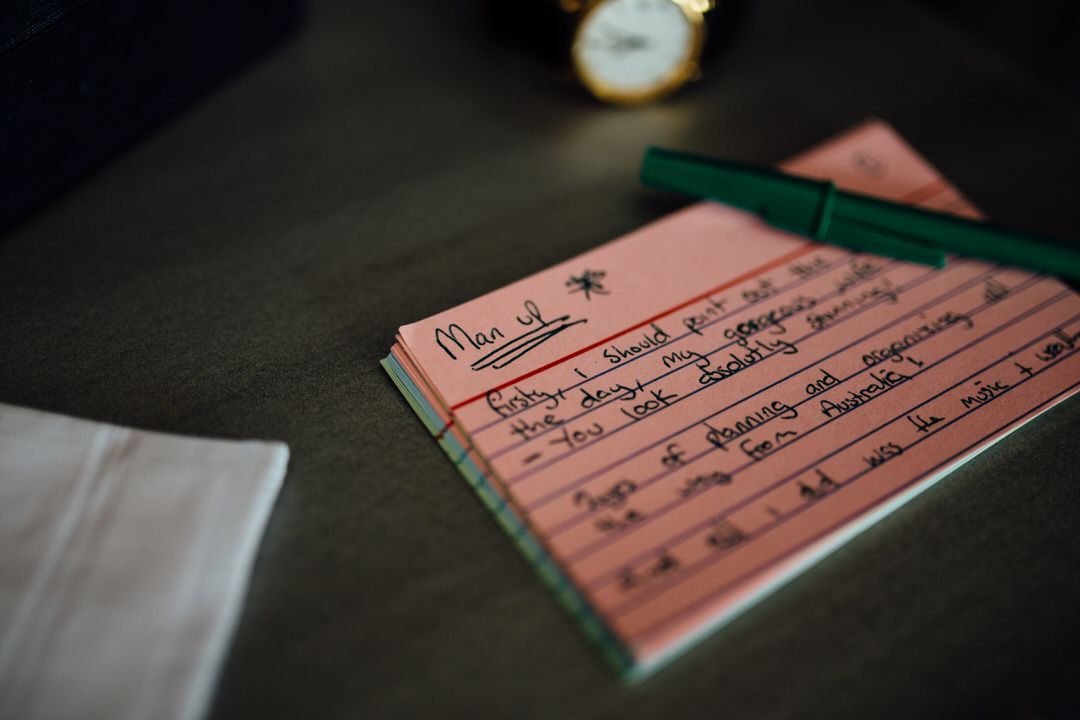 Vintage pink wedding documents and paperwork in dramatic lighting.
