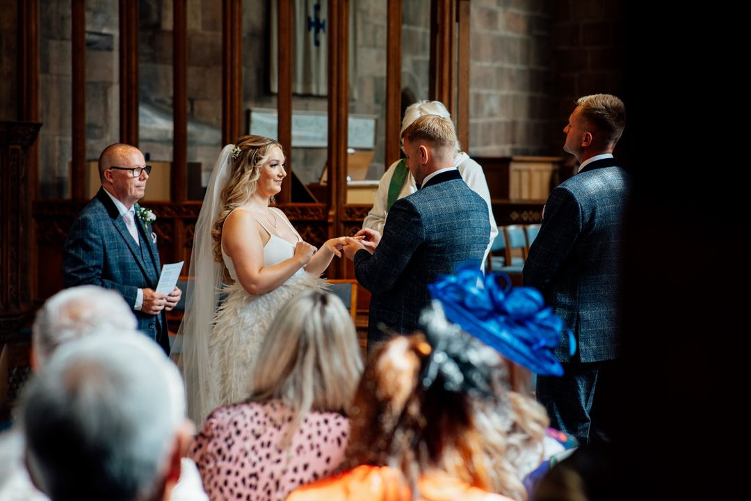 Wedding guests mingle in a rustic brick venue with atmospheric lighting.