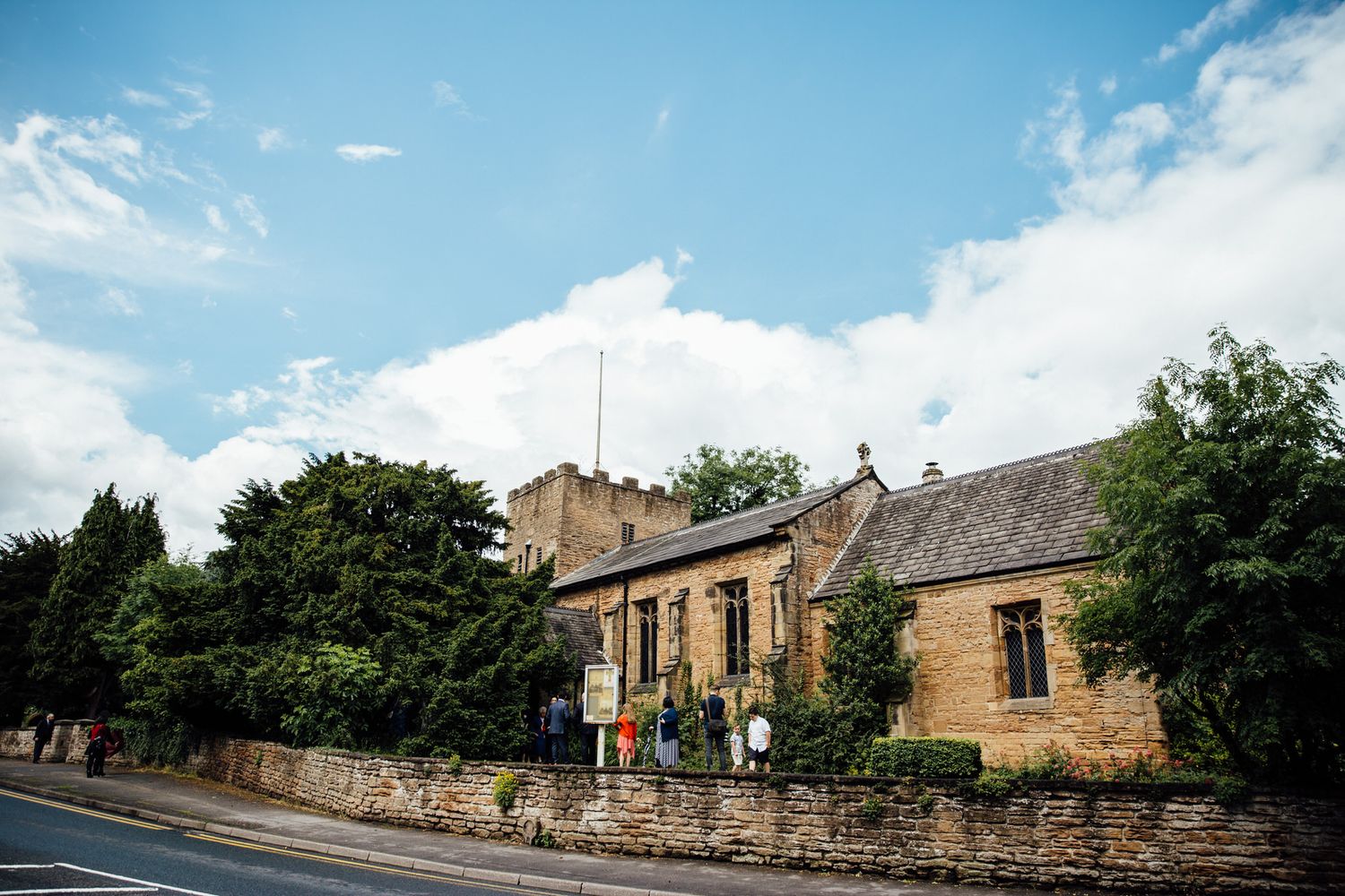 Panoramic view of stone church building under blue summer sky.