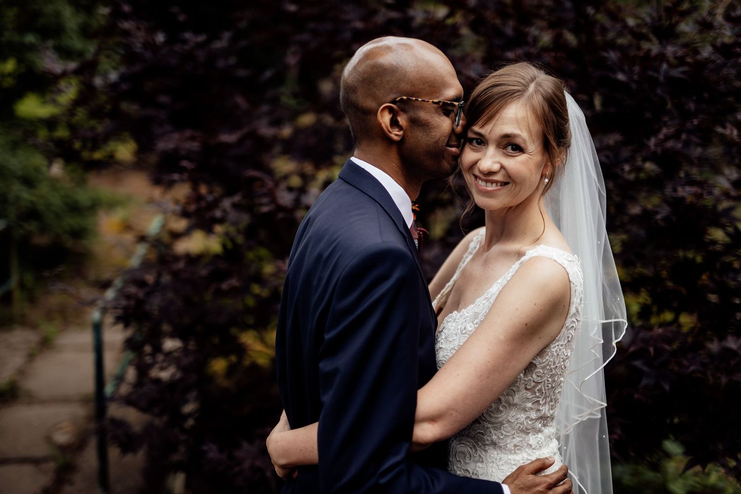 Intimate wedding portraits taken against autumn foliage backdrop.
