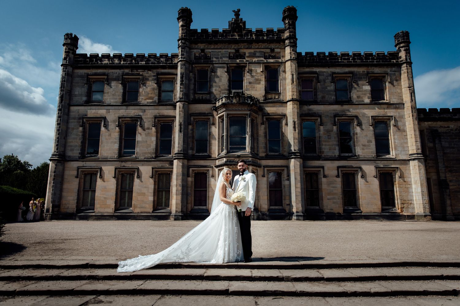 Elegant stone castle facade serves as backdrop for wedding photography.