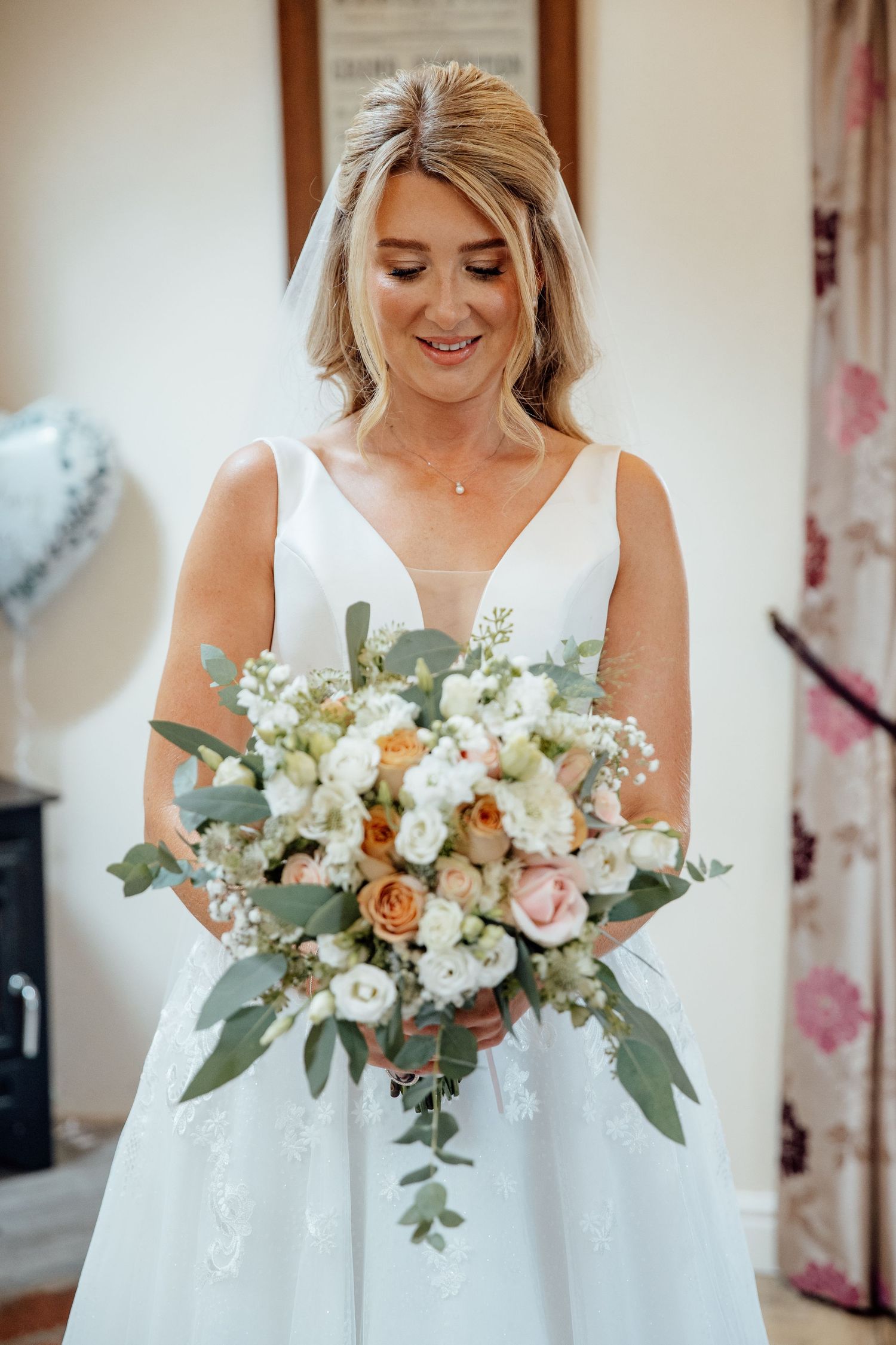 Elegant white bridal bouquet with eucalyptus and roses photographed in natural light.