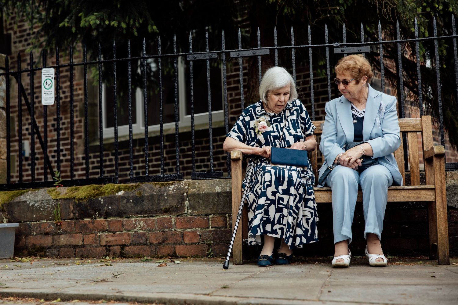 Guests sitting on steps of historic brick building during wedding celebration.