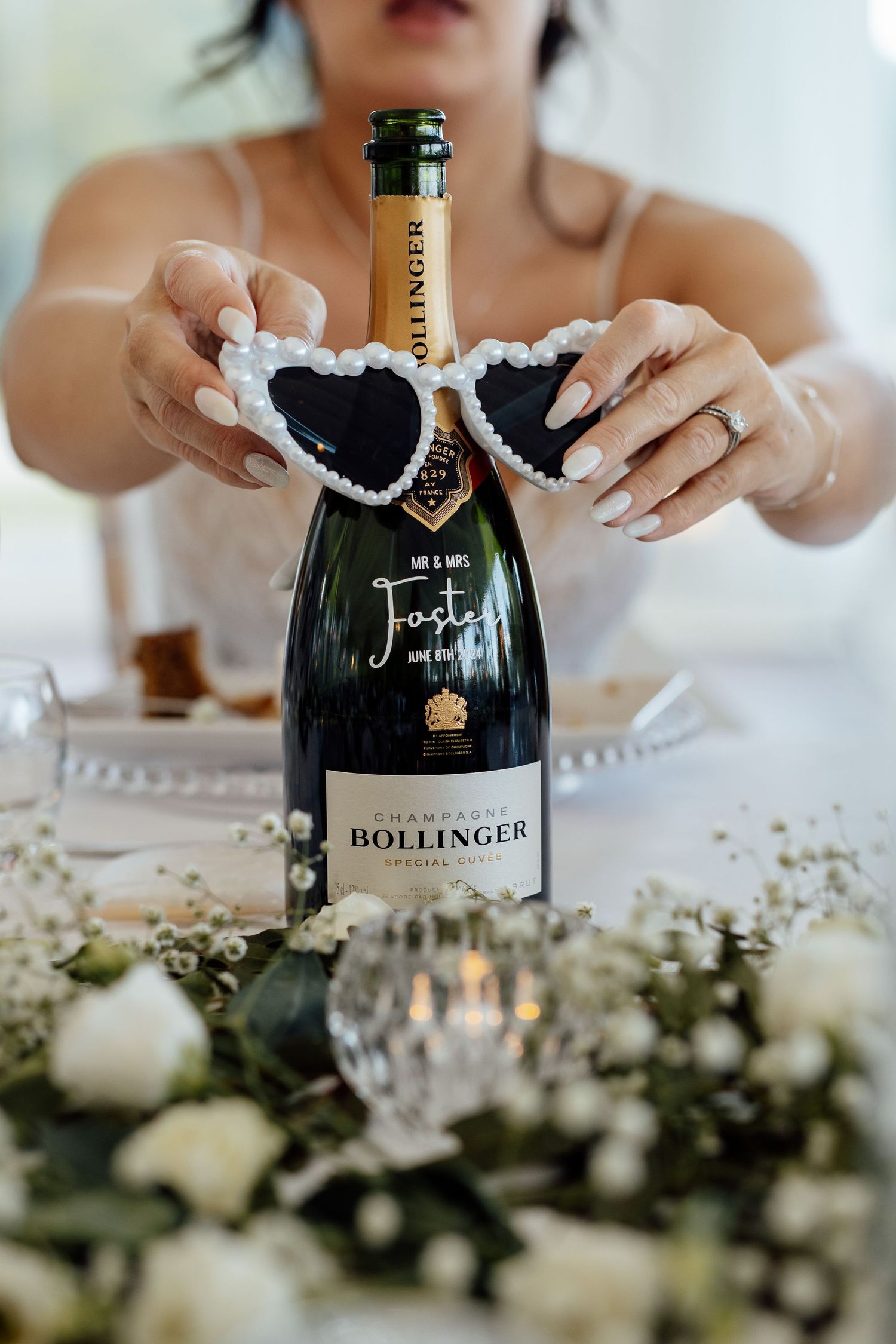 Bollinger champagne bottle with white lace detail on decorated table.