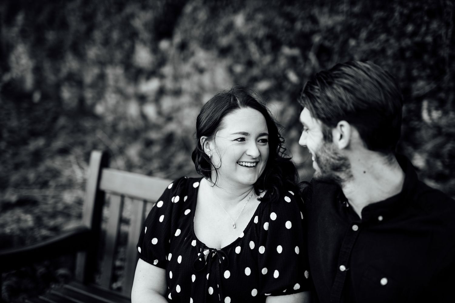 An intimate black and white photograph of a couple sharing a tender moment.