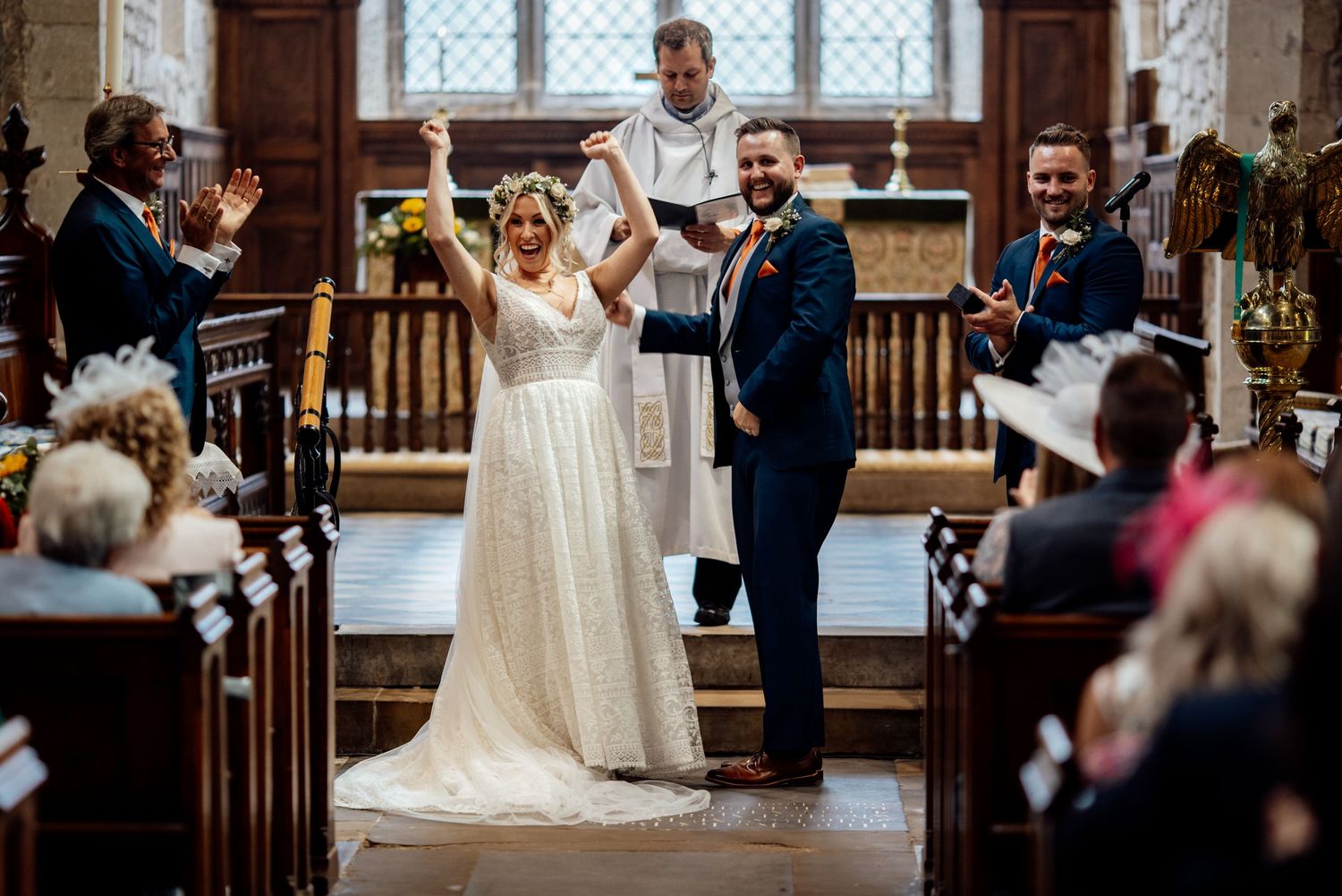 A wedding ceremony celebration in a historic church with stone architecture and stained glass windows.