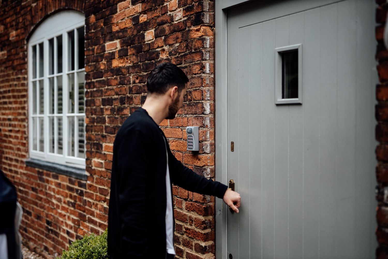Grey painted doors and brick exterior of historic mill building.