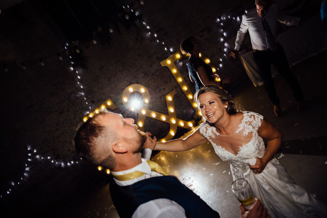 Romantic nighttime sparkler photos with twinkling lights create magical wedding atmosphere.