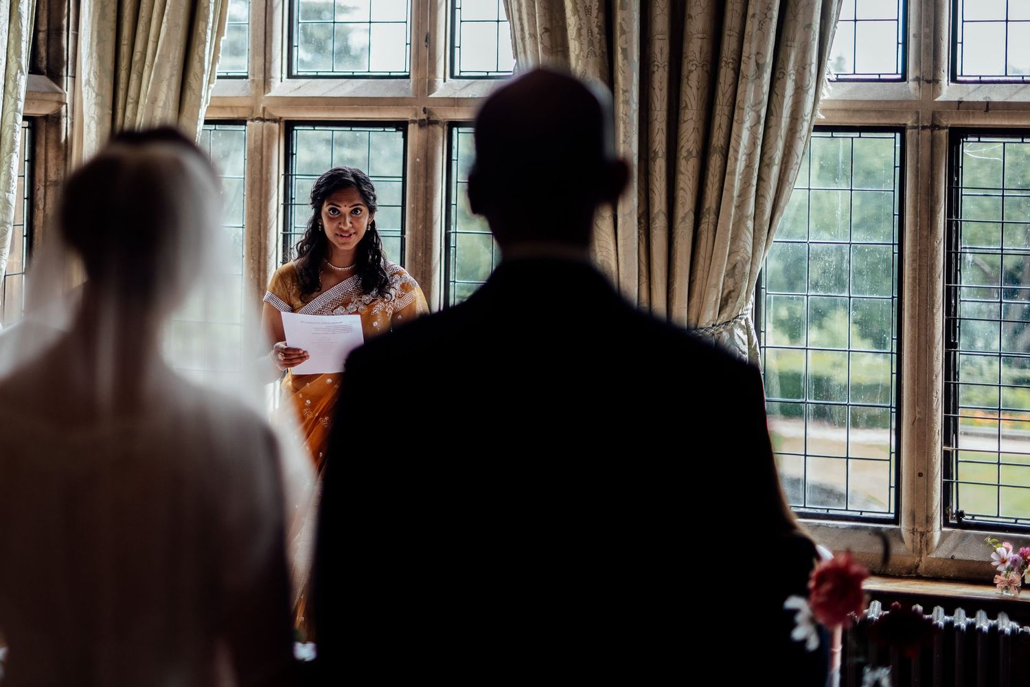 Large windows with elegant drapes frame a formal indoor gathering space.