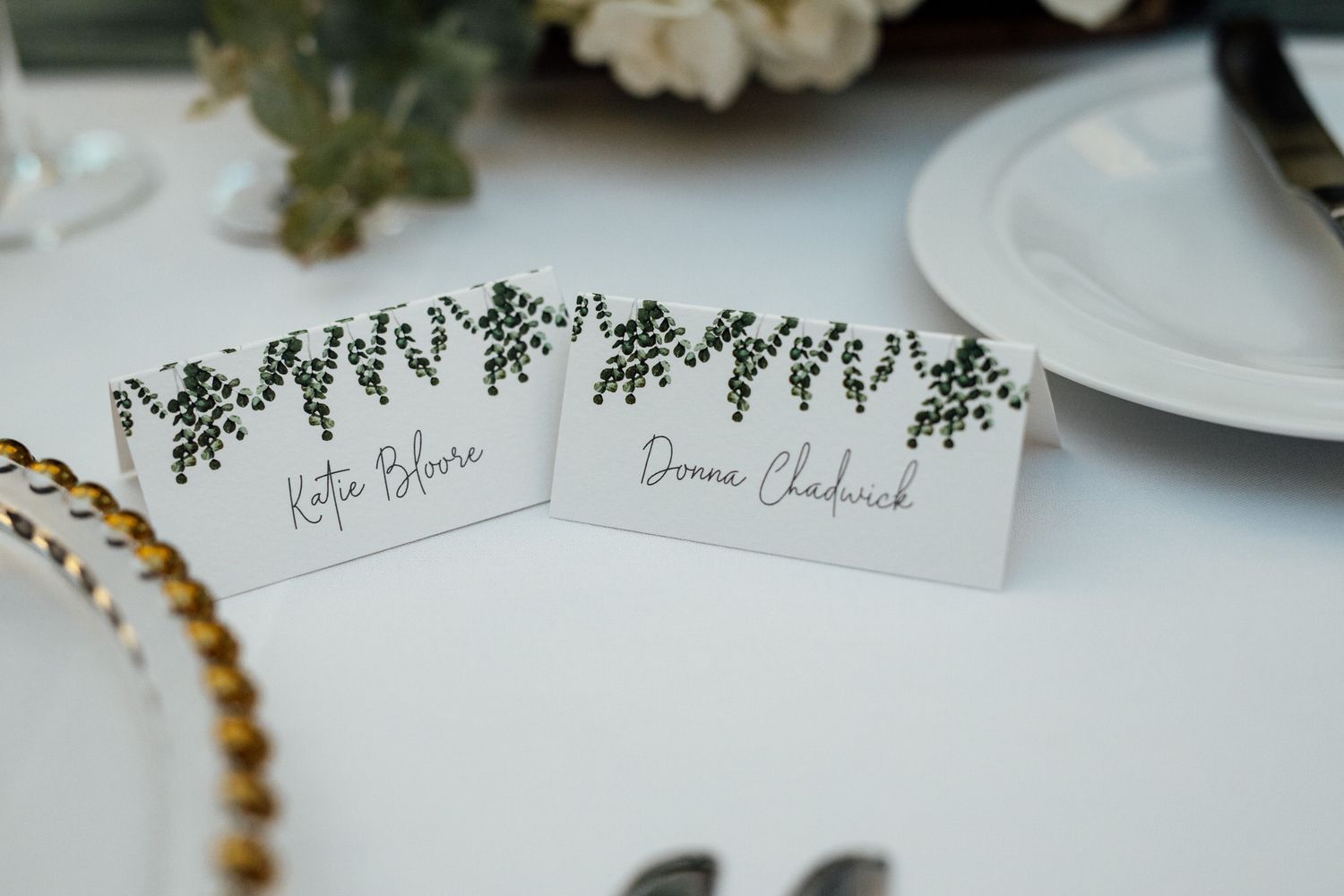 Delicate floral illustrations and calligraphy on wedding stationery with white roses.