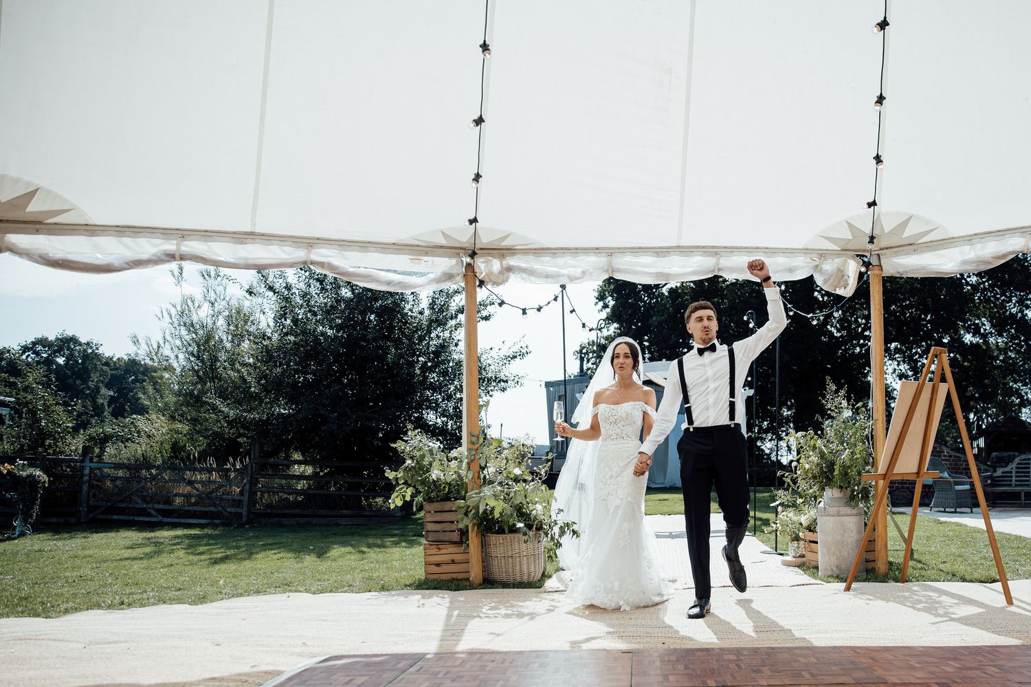 Wedding reception setup with white tent and outdoor decor.