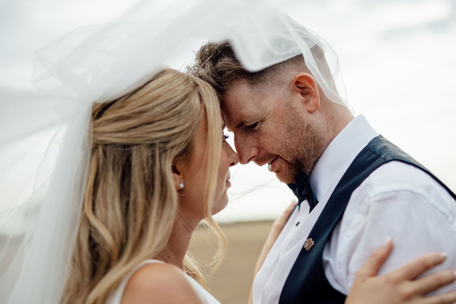 Intimate wedding moment captured against a bright white background.