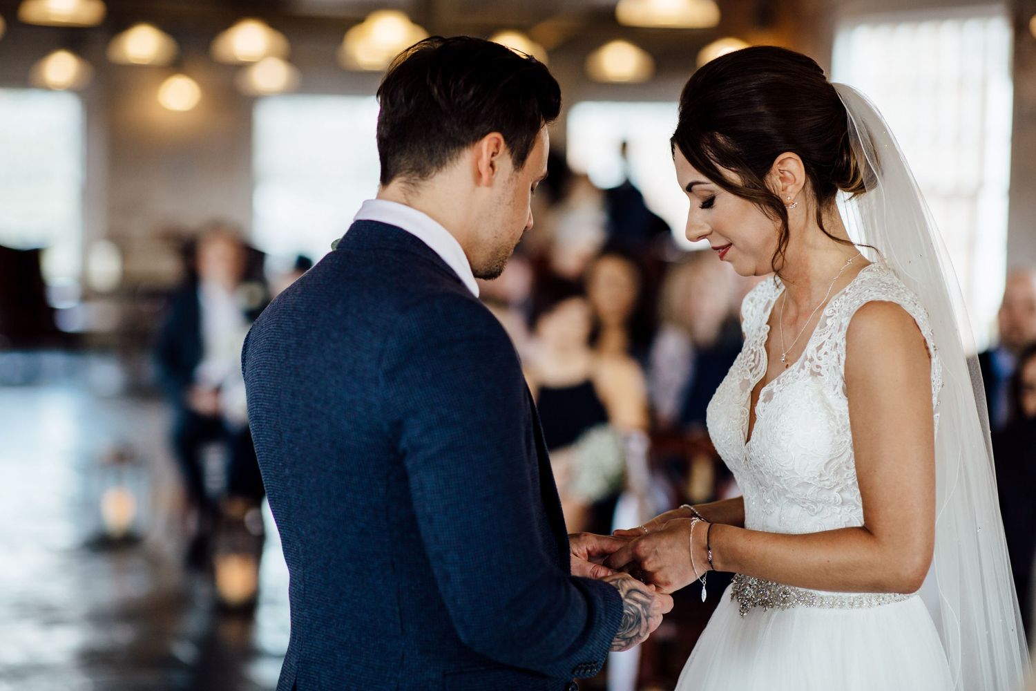 First dance moment between newlyweds in elegant venue with overhead lighting.