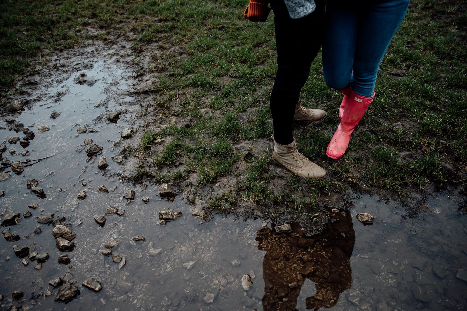 Close-up of hiking boots on rocky riverside trail during outdoor adventure.