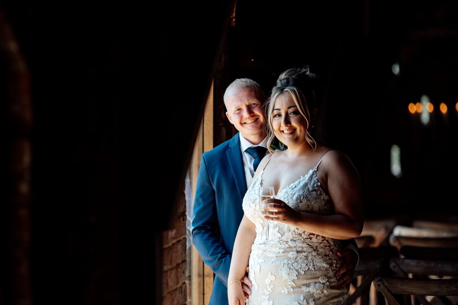 Couple sharing an intimate moment in natural window light at their wedding venue.