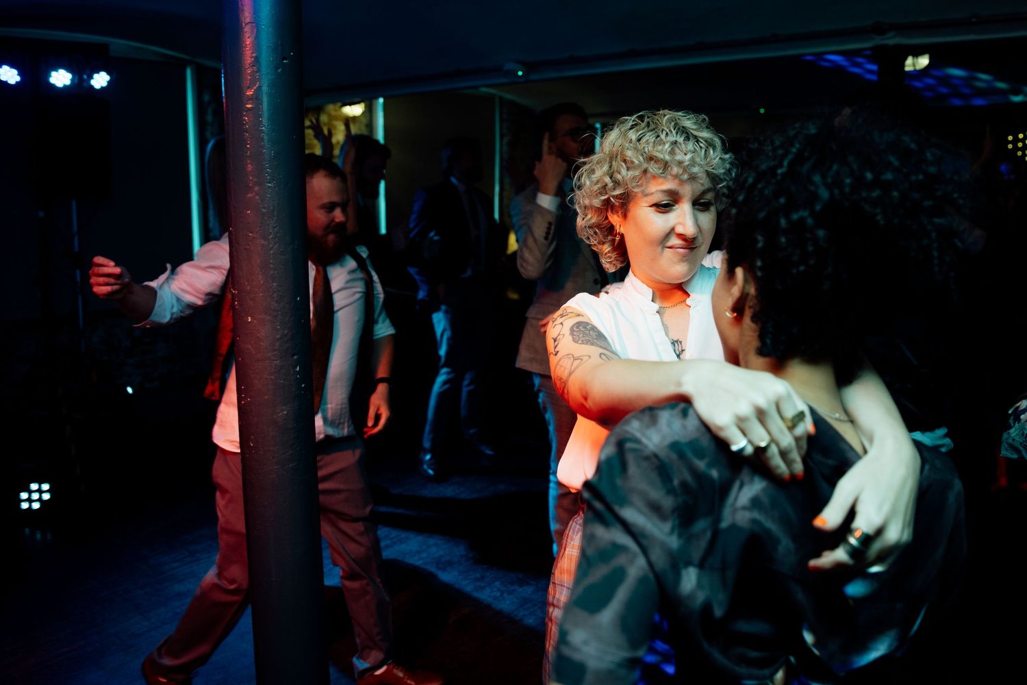 Dance floor moments at a wedding reception with blue lighting effects.