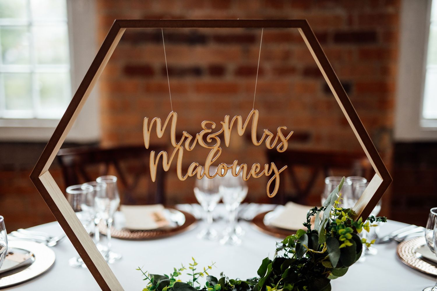 Elegant geometric wedding signage and table settings with floral accents.
