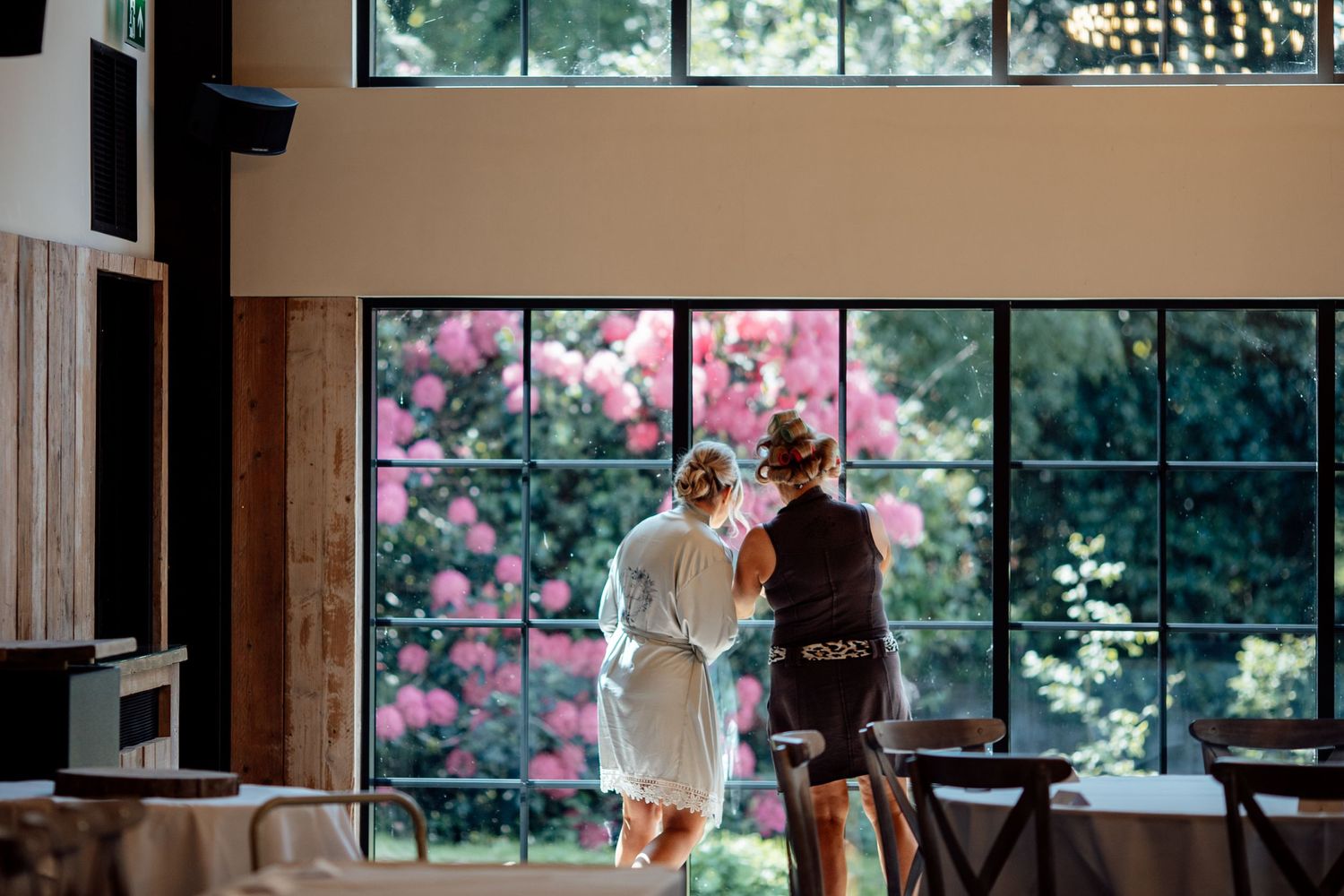 Modern wedding venue interior with large windows and natural lighting.