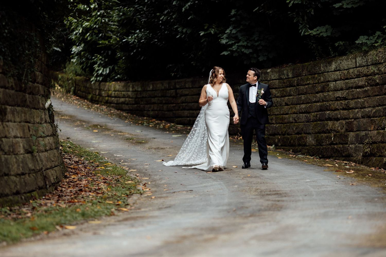 Stone pathway winds through an elegant garden setting perfect for wedding photography.