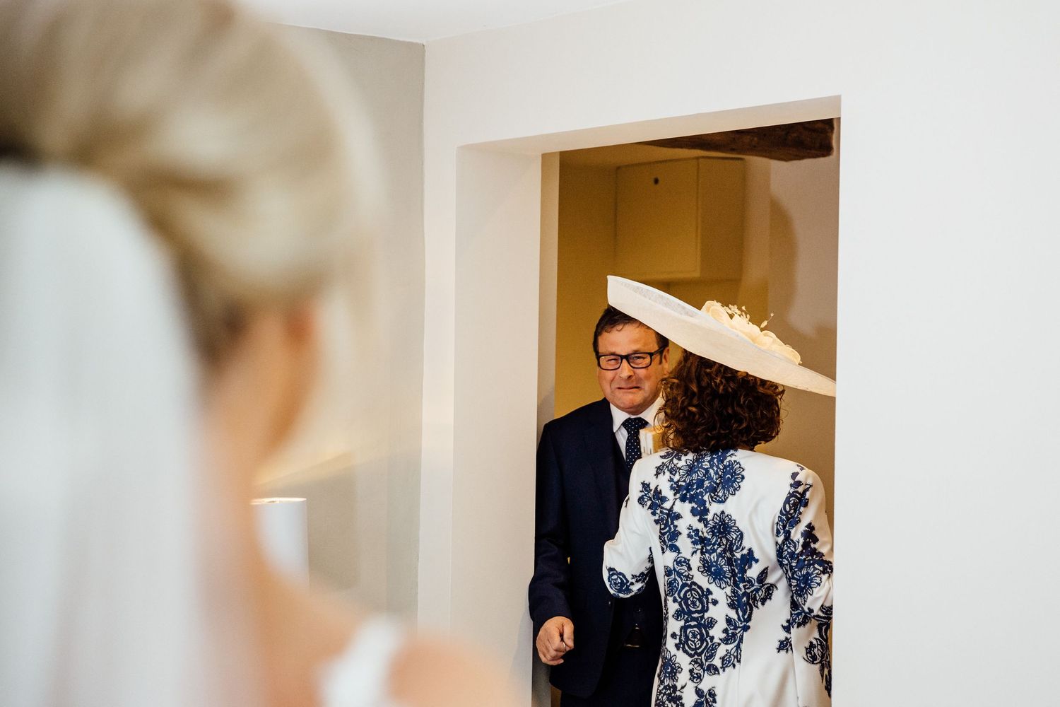 Elegant hallway scene during wedding preparations with formal attire visible.