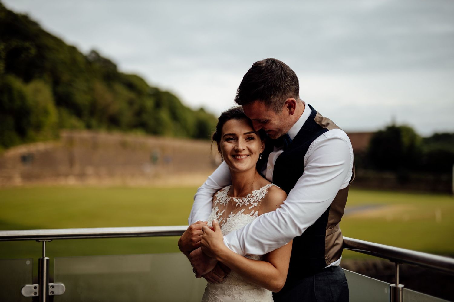 Romantic outdoor couple portrait against an overcast sky.