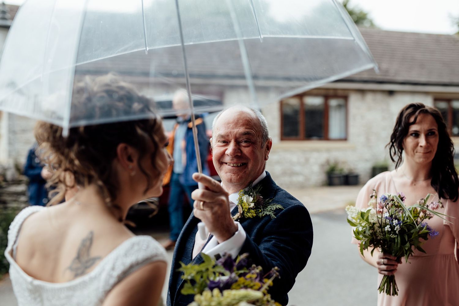 Outdoor wedding celebration with guests mingling under cloudy skies.