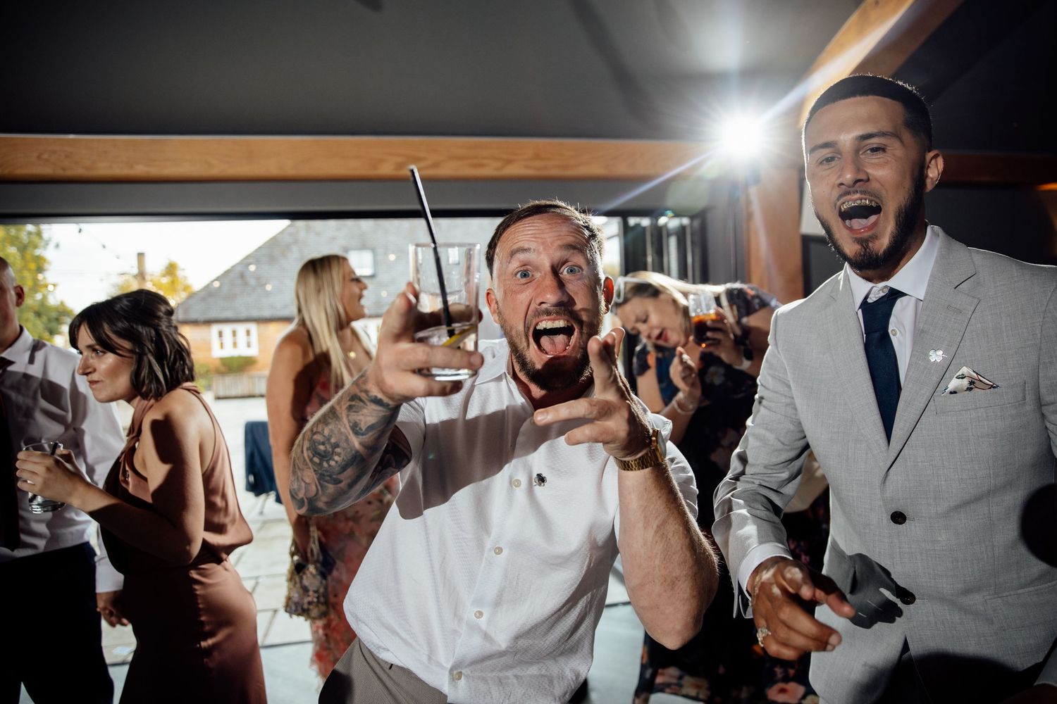 Energetic dance floor moment at wedding reception with guests celebrating.