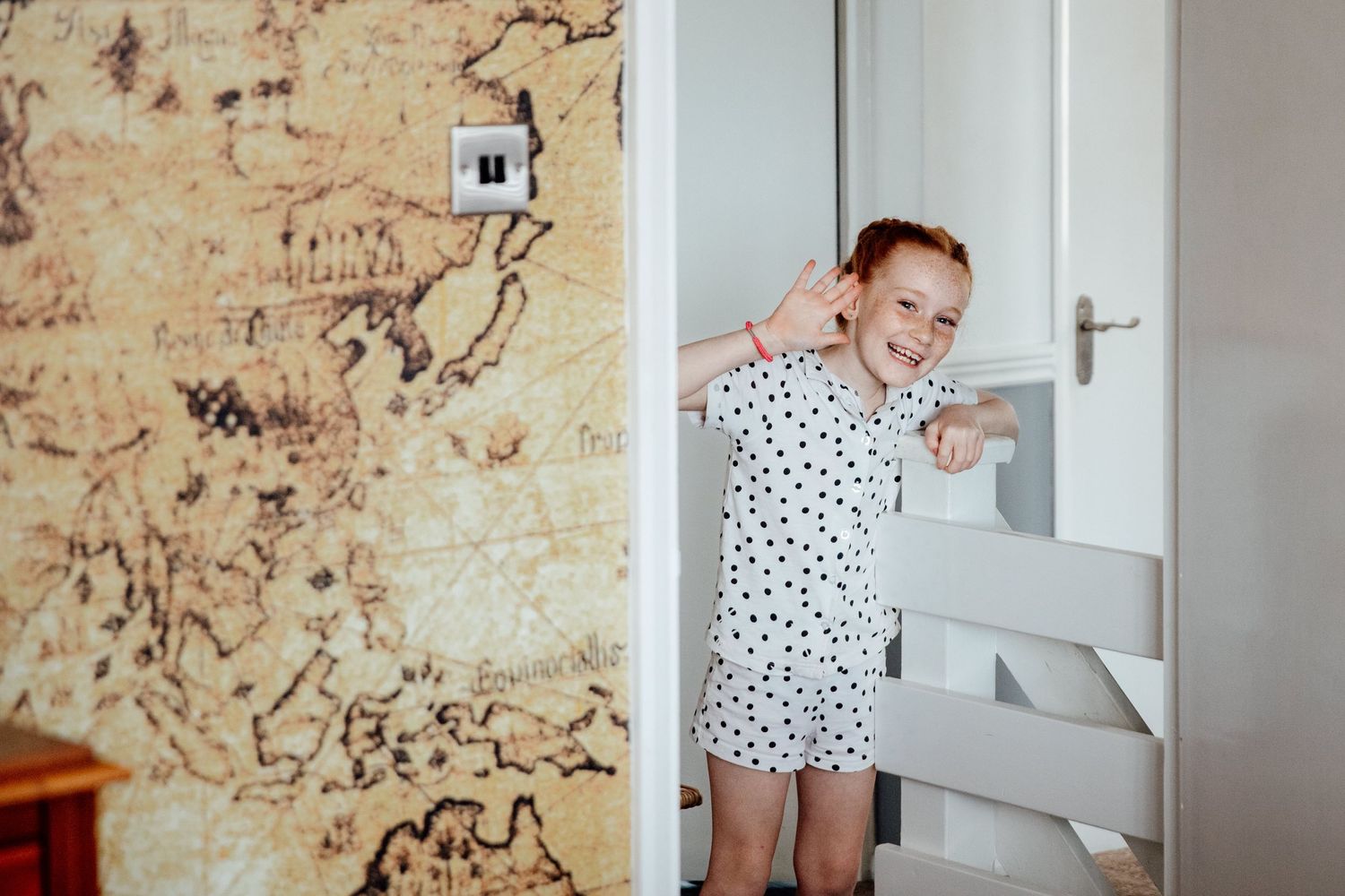 Getting ready scene with polka dot robe near window with vintage wallpaper.