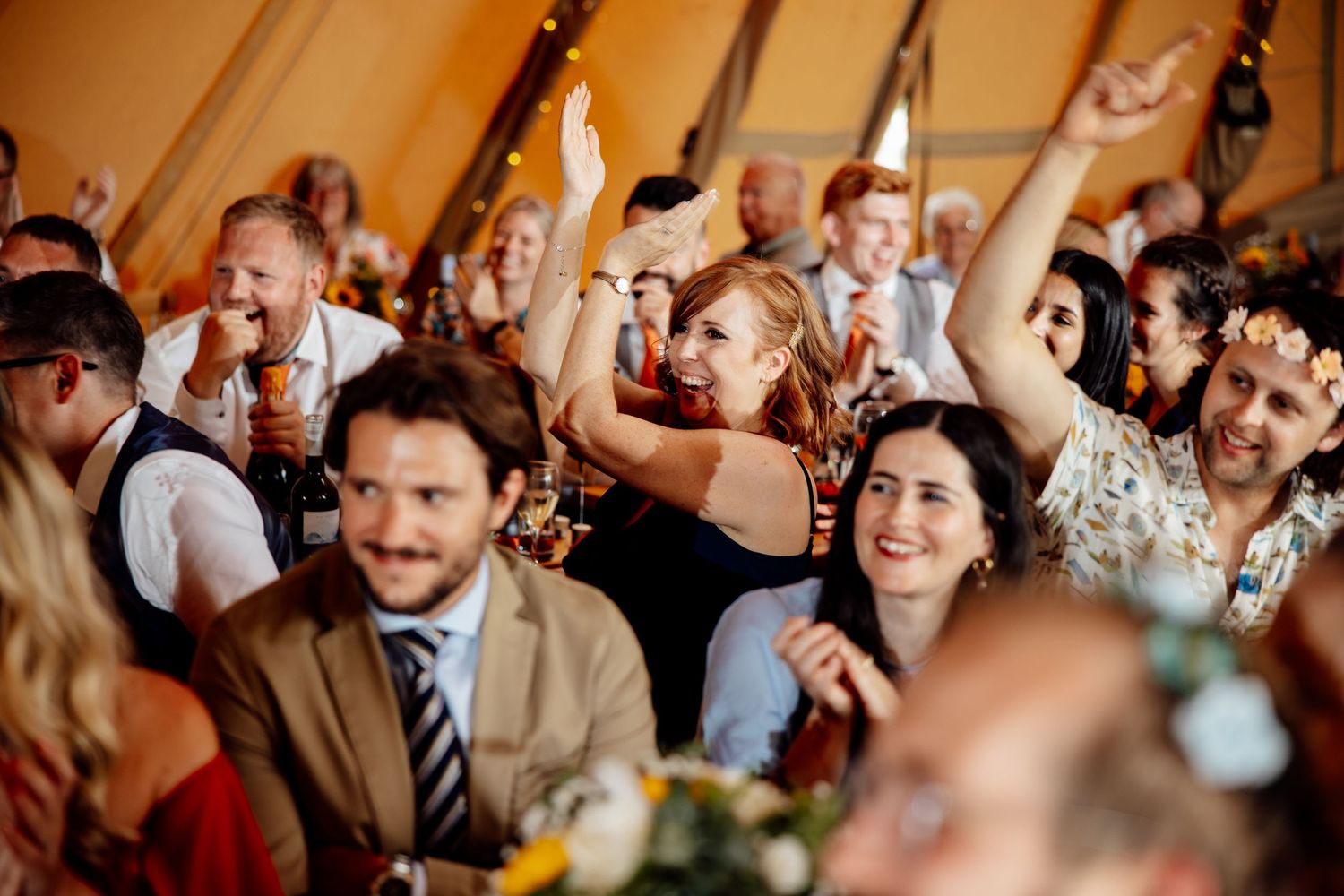 Joyful wedding reception guests laugh and celebrate during a festive party.