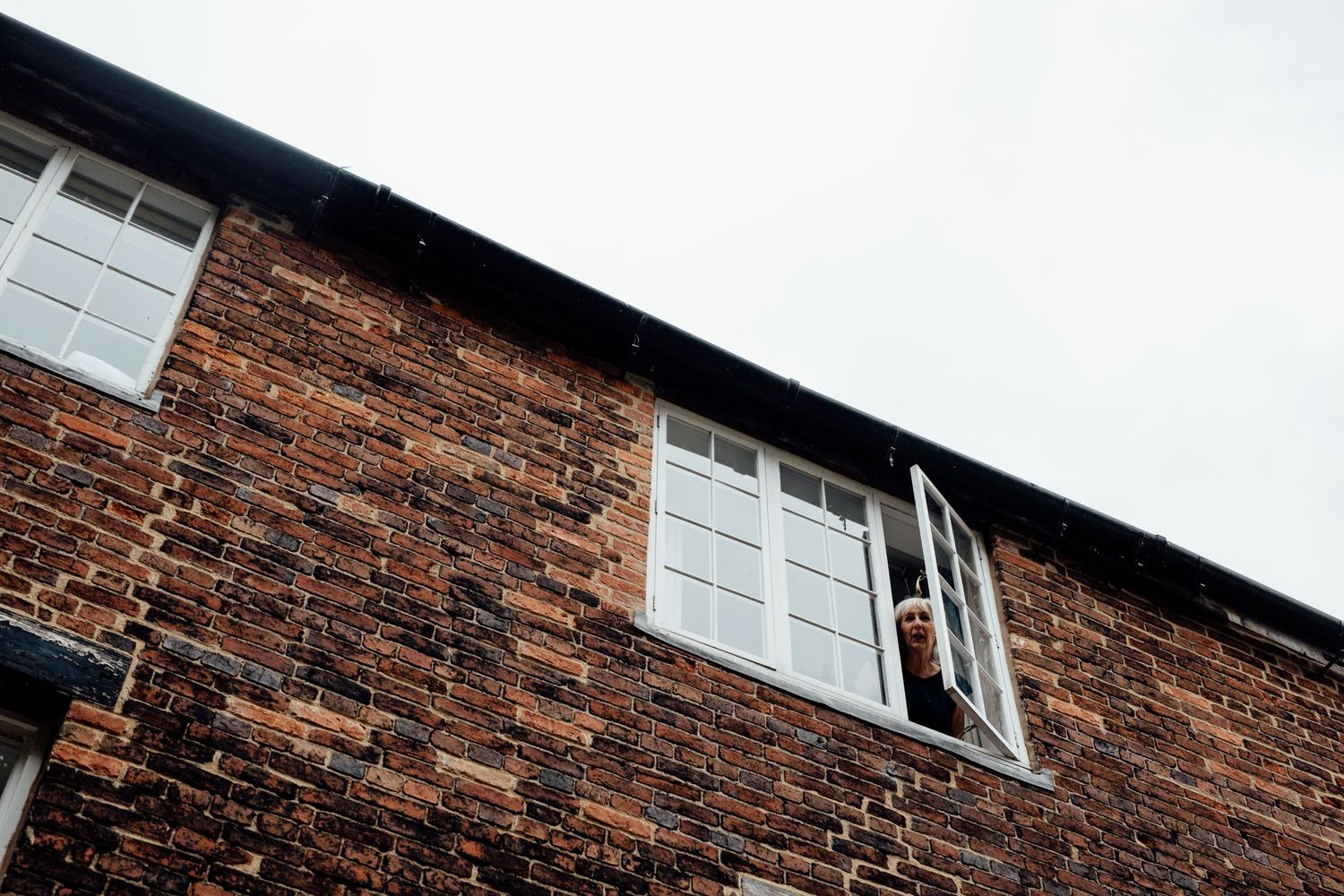Architectural detail of a historic brick building with white window frames.