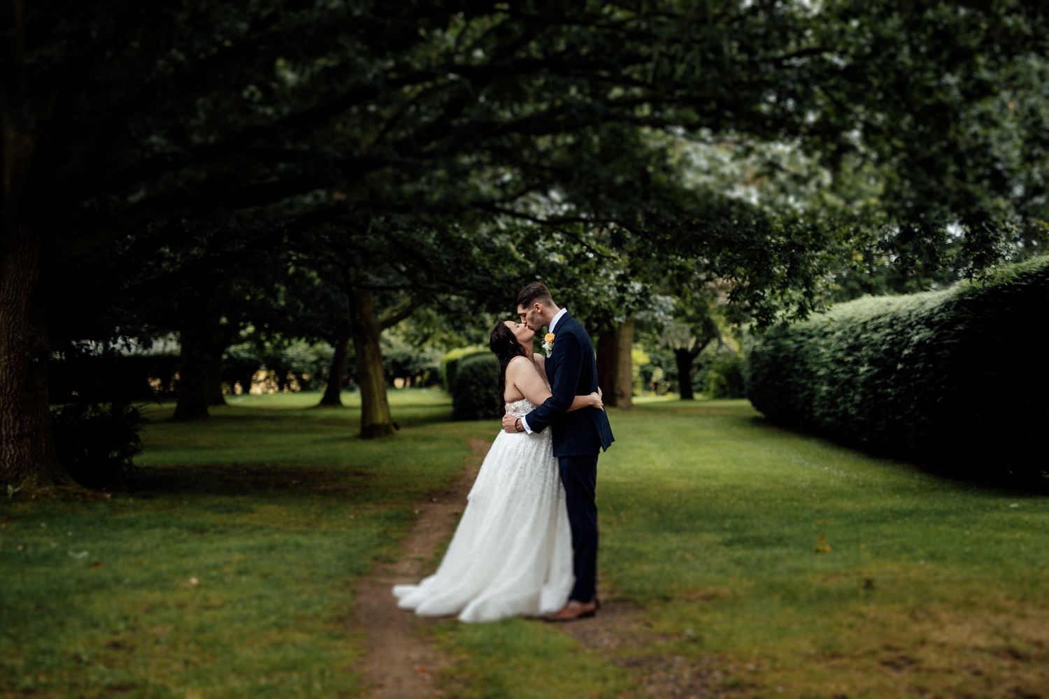 Intimate wedding moment captured in a verdant garden setting.