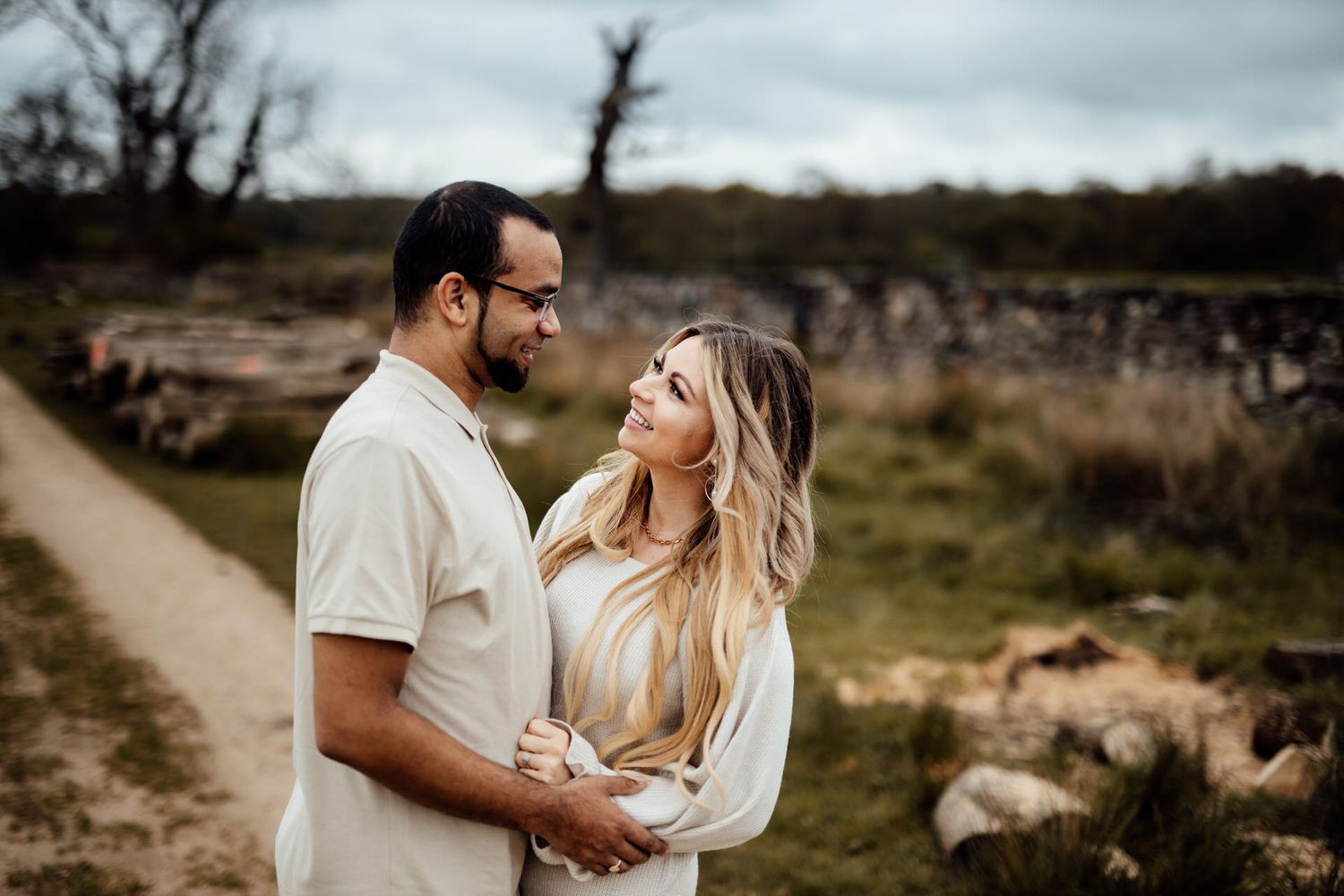 A couple shares romantic moments on a nature path during an outdoor photo session.