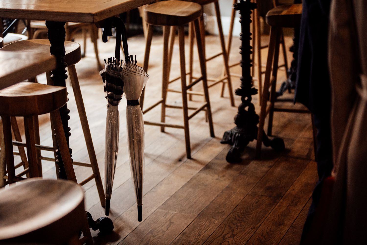 Interior of a rustic restaurant with wooden floors and bar stools.