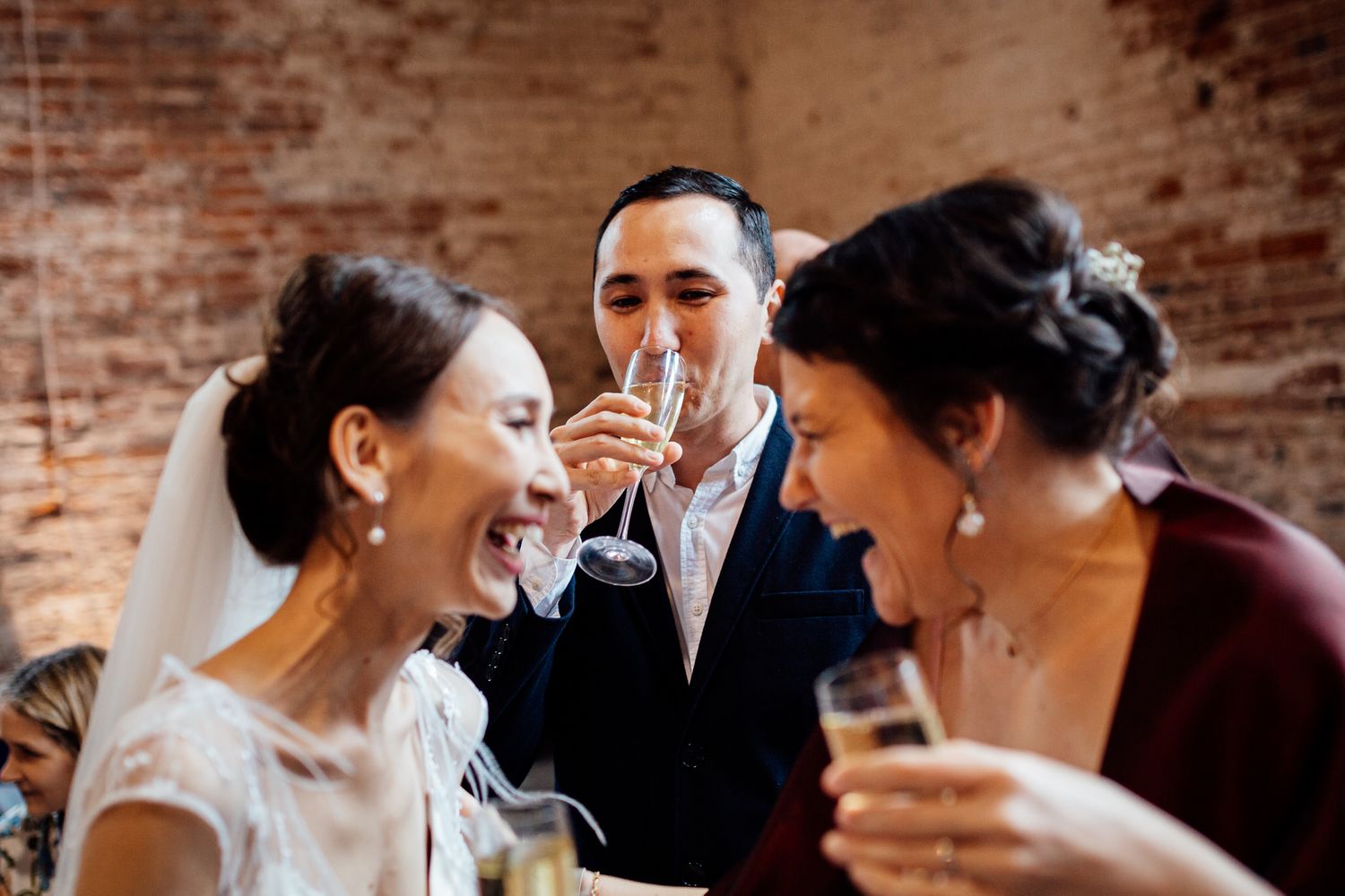 Wedding celebration moment with guests sharing drinks and laughter.