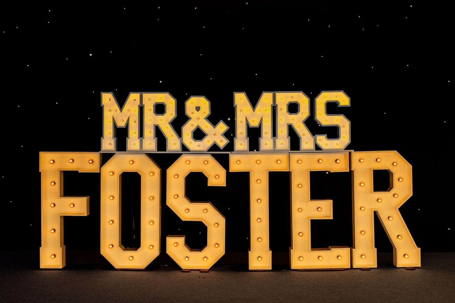 Gold metallic text animation showing 'MR & MRS FOSTER' against a dark background.
