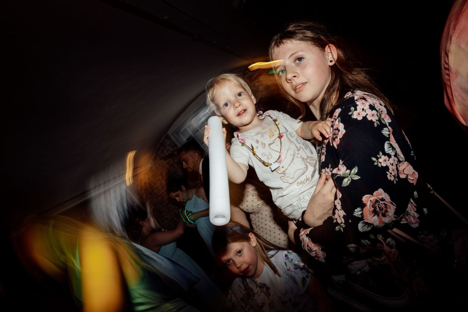 Wedding reception dance party with motion blur and festive lighting.
