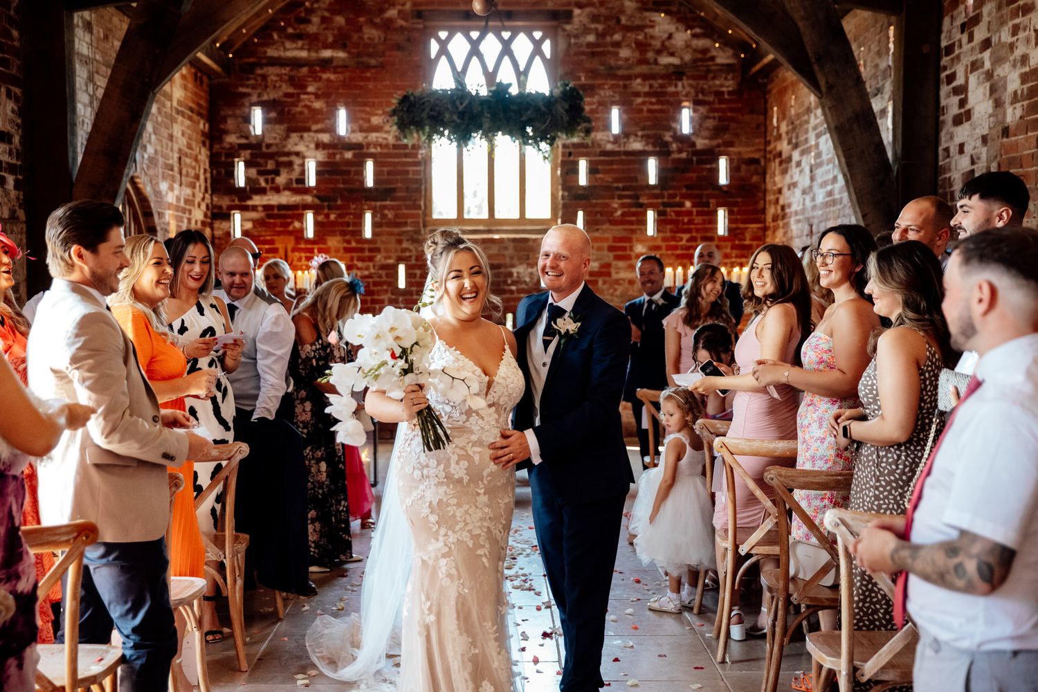 Wedding ceremony in rustic brick venue with exposed beams and romantic lighting.