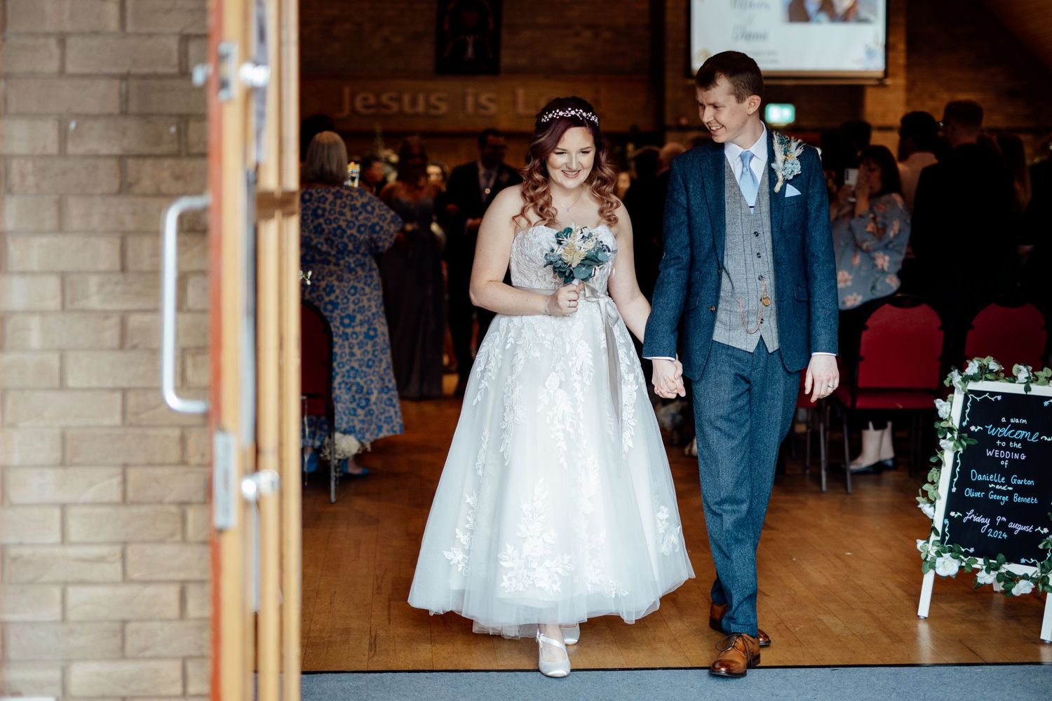 A couple exits a church doorway after their wedding ceremony.