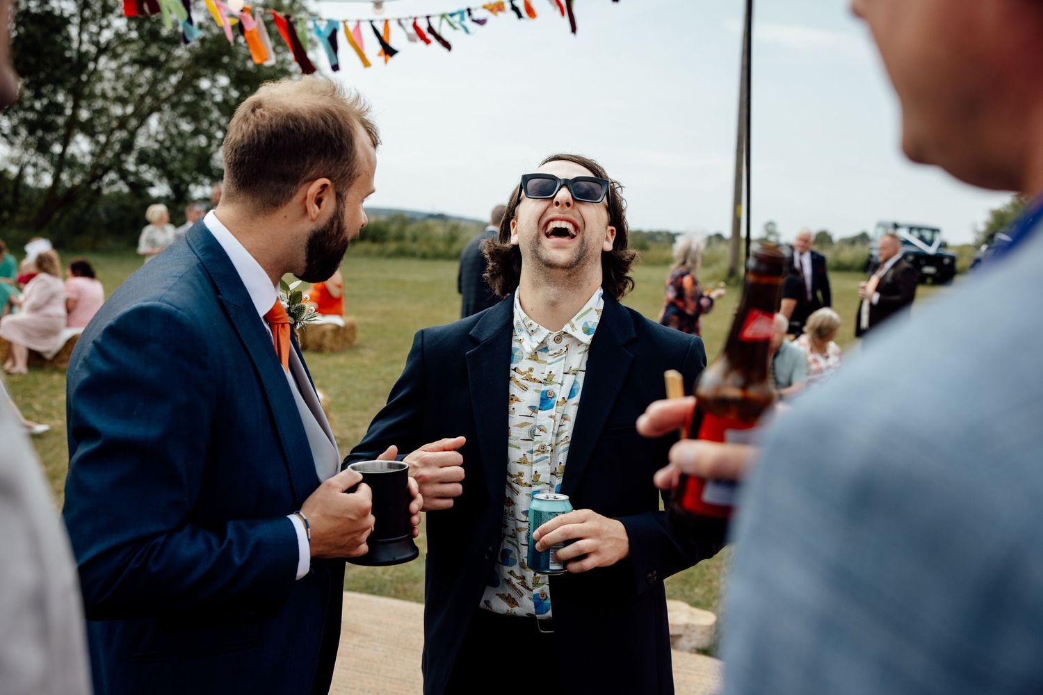 Candid moments of guests laughing during outdoor wedding festivities.