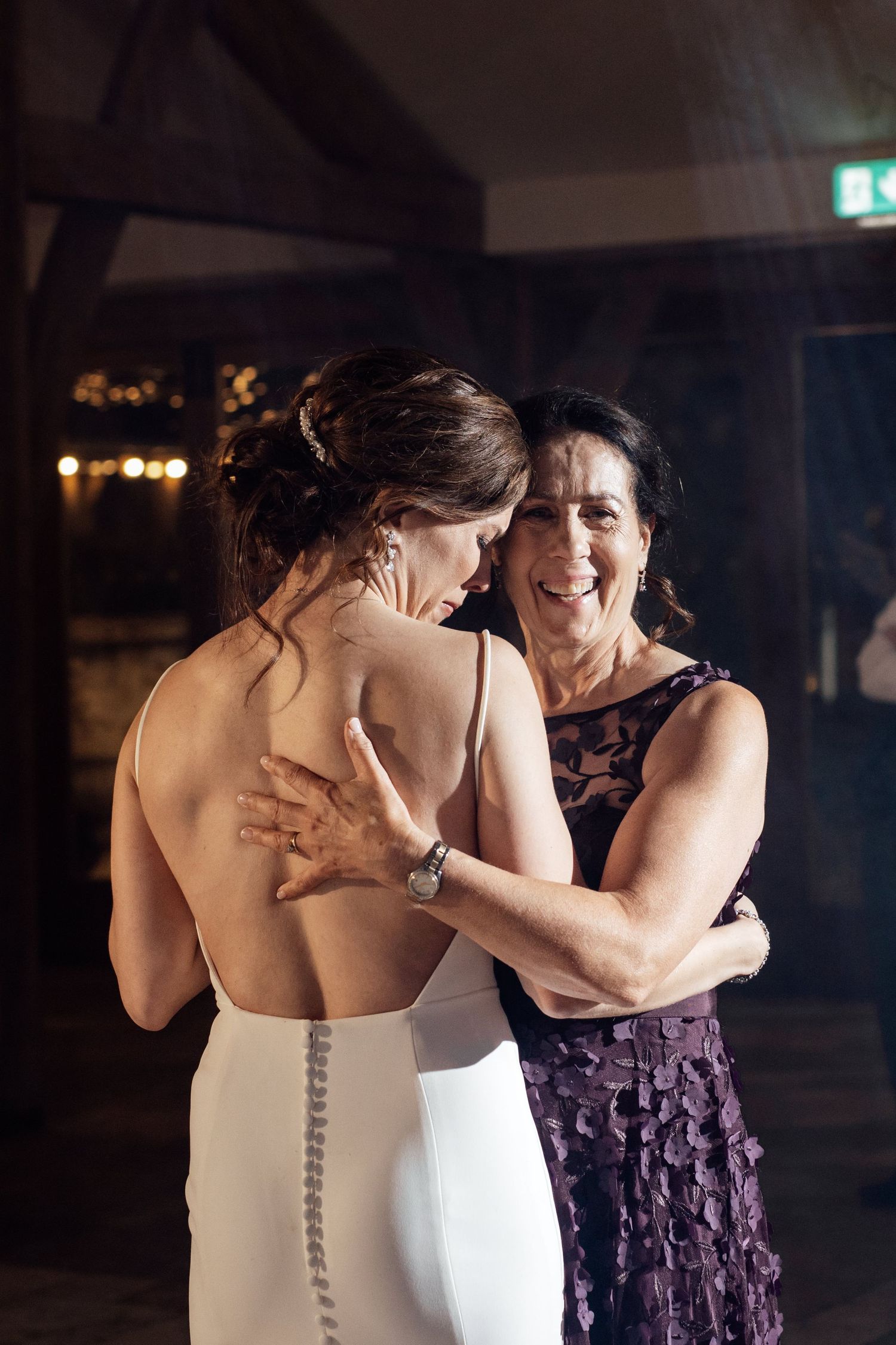 Emotional moments shared during an indoor evening wedding celebration.