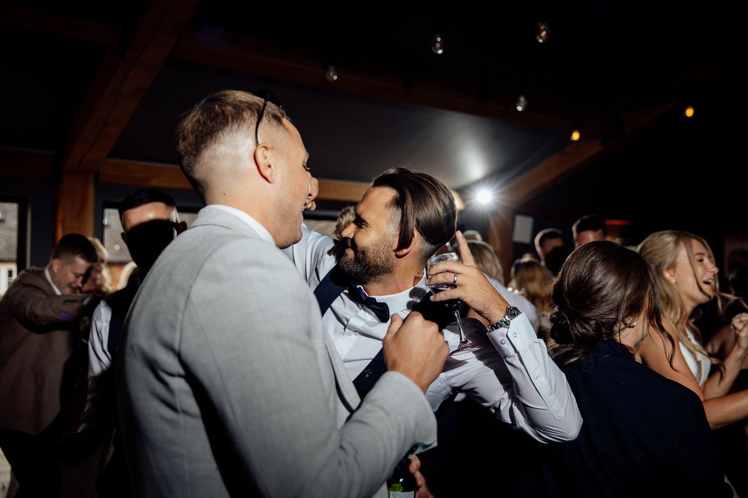 Wedding photographers capture candid moments during an evening reception.