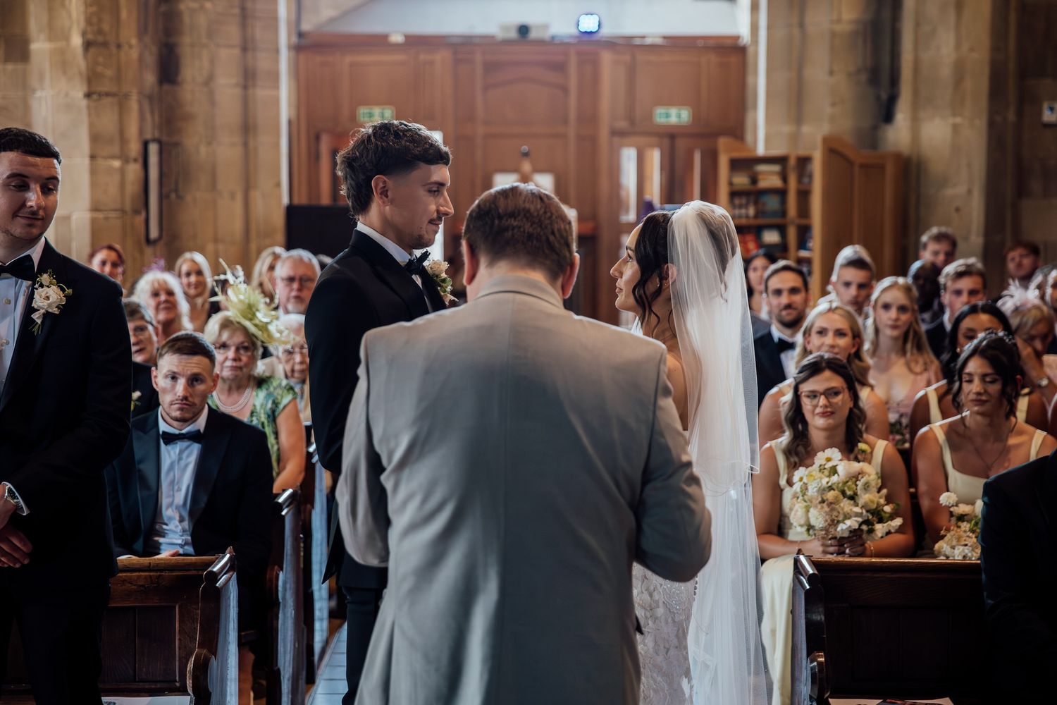 Wedding reception celebration in a grand church hall with guests looking on.