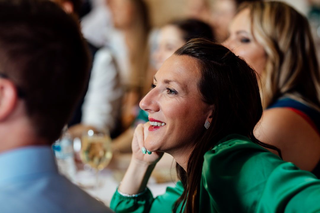Guests smile and enjoy emotional moments during wedding reception speeches.