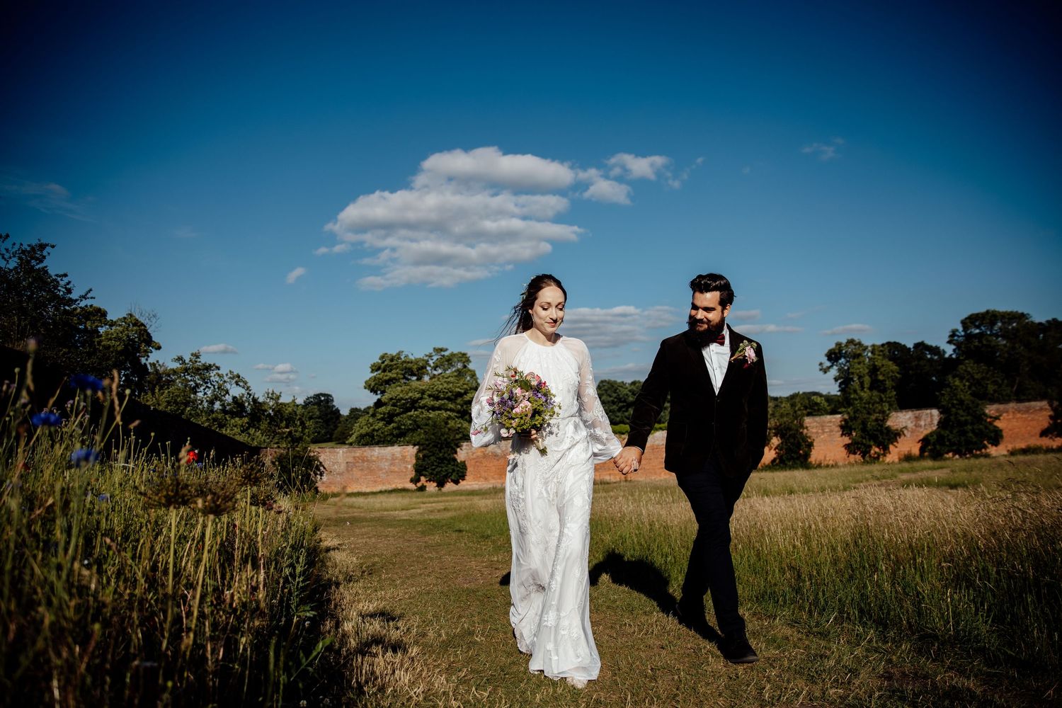 Elegant wedding photography session in a rustic outdoor field with dramatic sky backdrop.