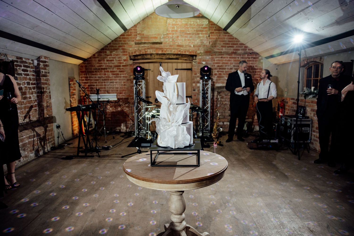 Rustic brick-walled venue space set up for a wedding celebration with ambient lighting.