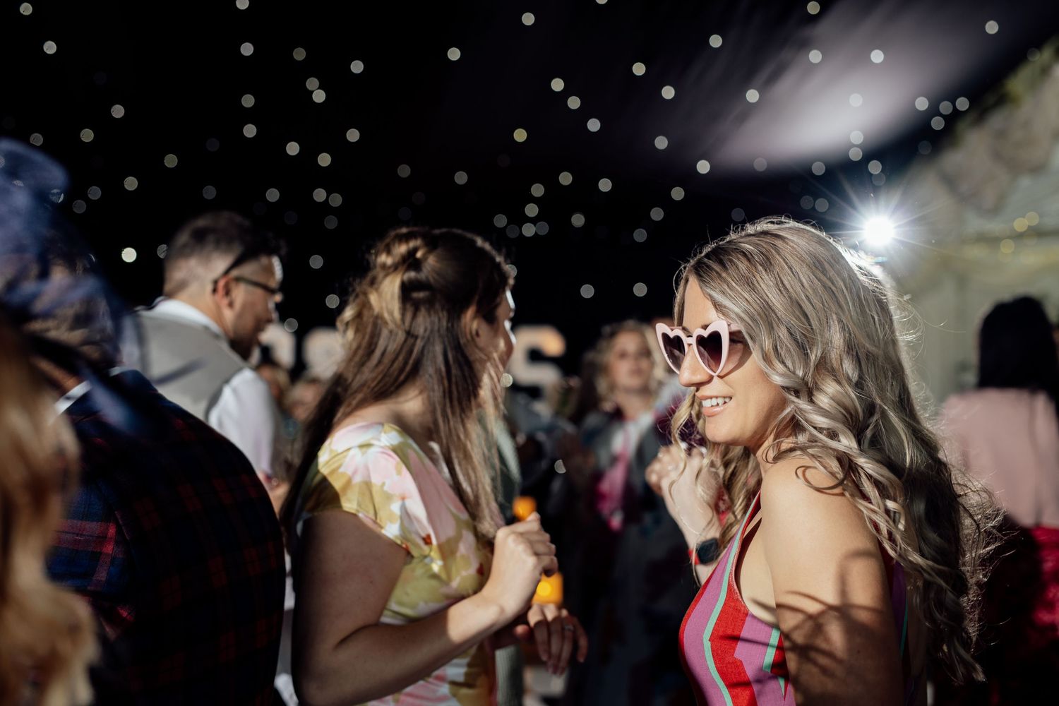 Dance floor scene with sparkly lighting effects at nighttime celebration.