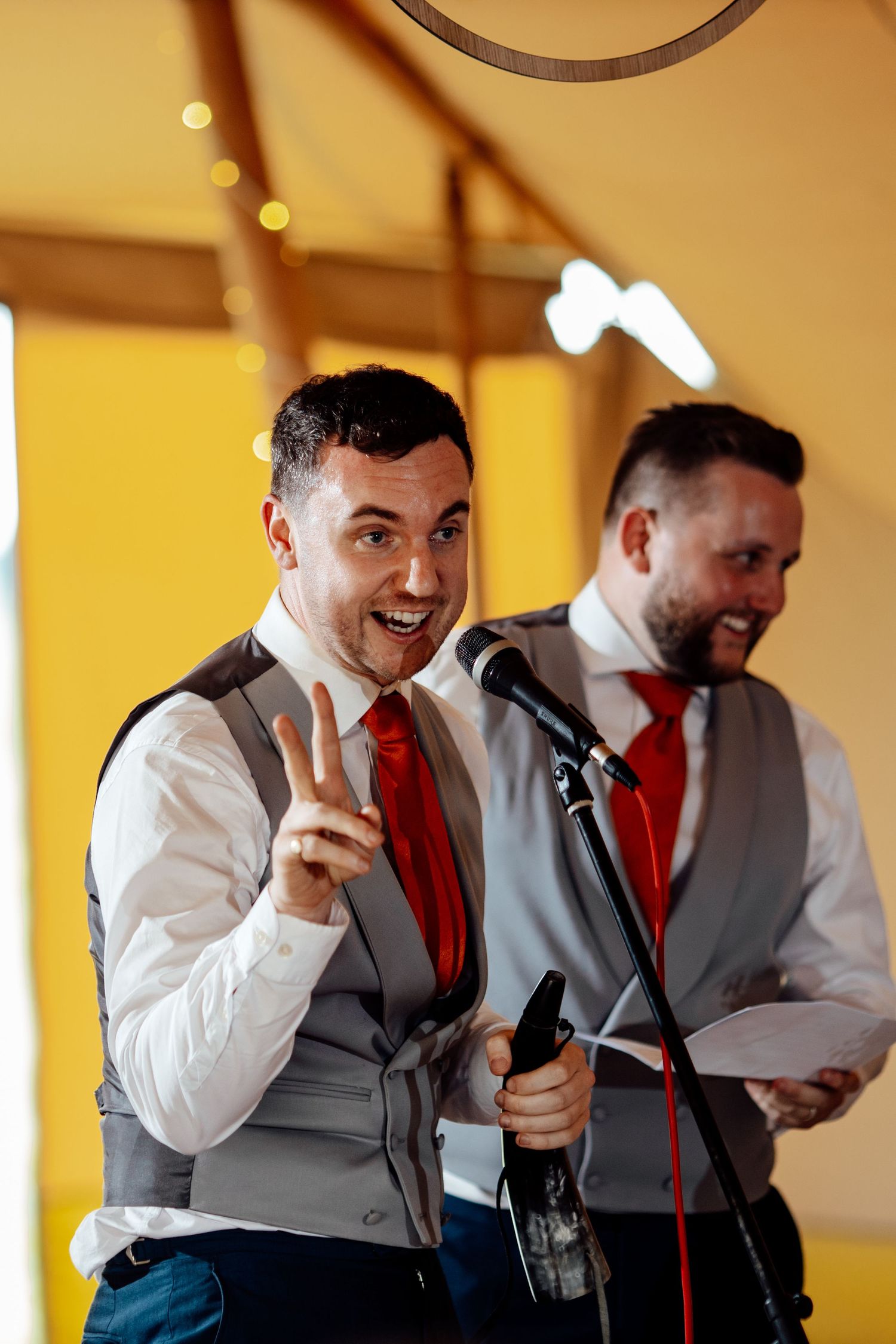 Wedding performers in matching red ties and vests entertaining guests at reception.