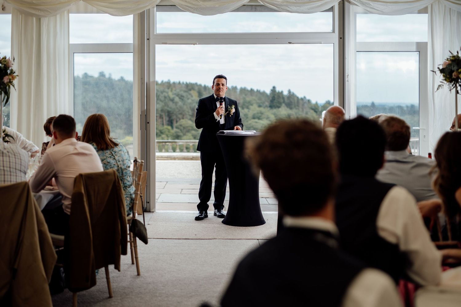 Large windows offer panoramic views during an indoor wedding reception.