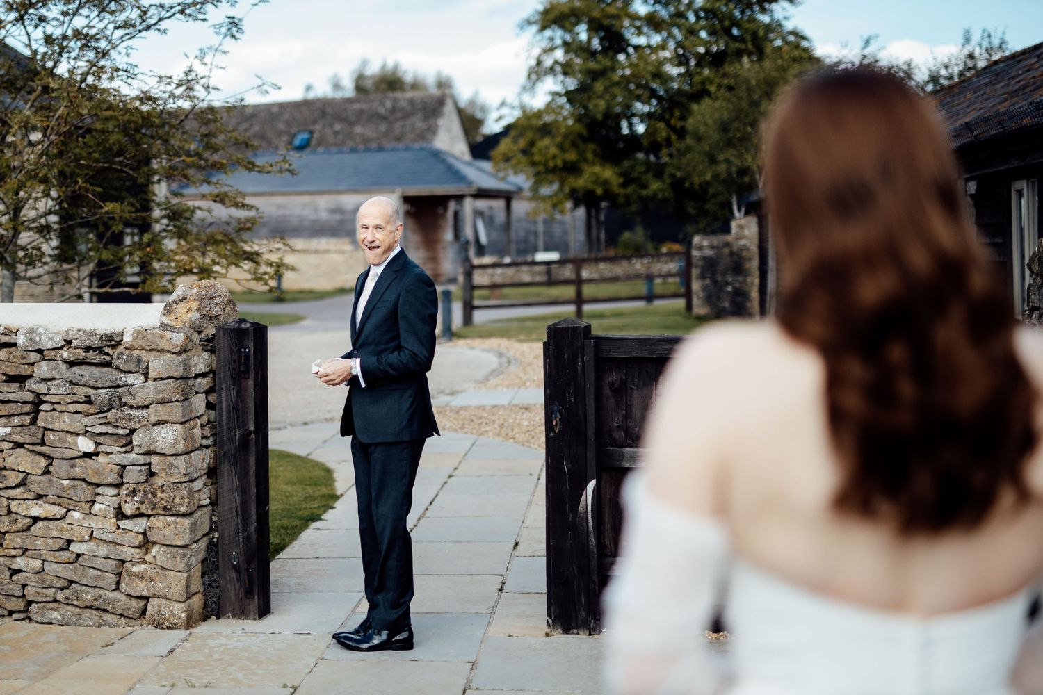 A couple takes romantic outdoor portraits against a stone wall backdrop on their wedding day.