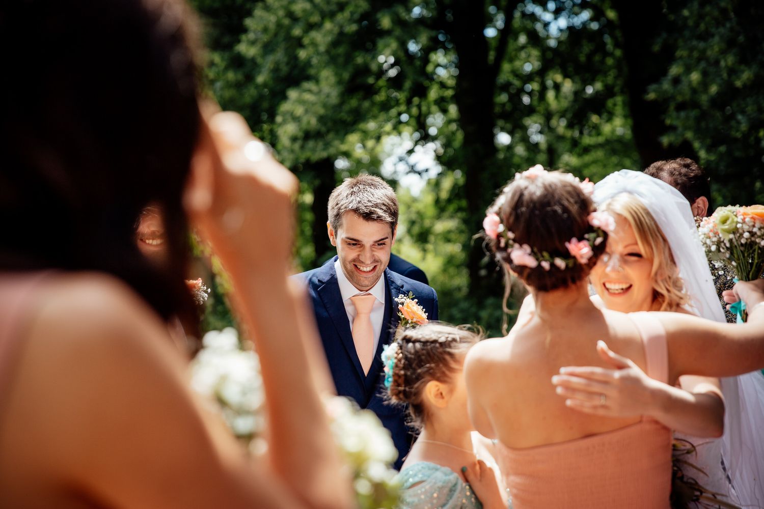 Candid moments captured during outdoor wedding celebration in garden setting.